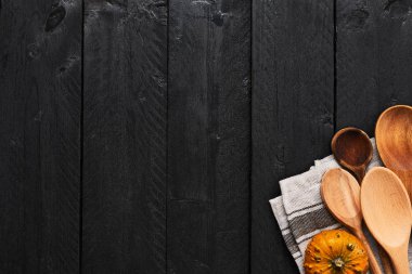 Tahta kaşıklar, kabak ve kopya alanı siyah ahşap zemin üzerine dishtowel. Koyu ahşap arka plan üzerinde üstten görünüm mutfak kaplar. Gıda arka plan, düz yatıyordu.