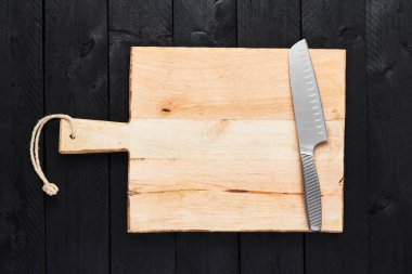 Doğrama Kurulu kopya alanı siyah ahşap zemin üzerine paslanmaz çelik sebze bıçakla üstten görünüm.