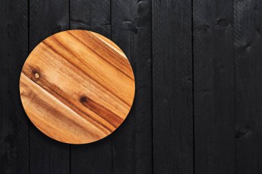 Yuvarlak ahşap servis tabağı üstten görünüm kopya alanı siyah ahşap tablo.