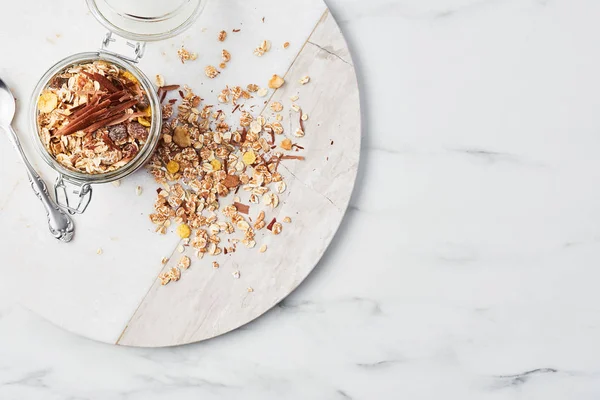 Üstten görünüm sağlıklı kahvaltı. Çilek sosu, yulaf ve beyaz mermer plaka mermer masa üzerinde hizmet veren çikolata sağlıklı yoğurt kavanoz. Kopya alanı.