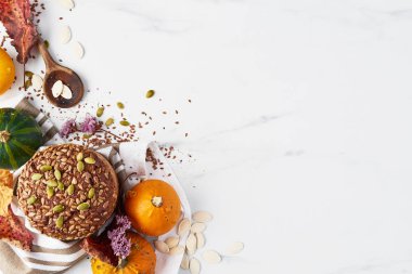 Sonbahar kepekli ekmek en iyi görünümü pumpkins, tohumu, keten ve beyaz mermer masada tahta kaşık ile beyaz mermer tabloda. Kopya alanı.