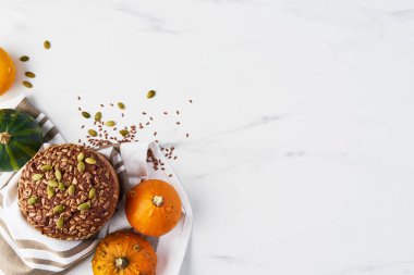 Sonbahar kepekli ekmek en iyi görünümü pumpkins, tohum ve keten beyaz mermer masada beyaz mermer masada. Kopya alanı.