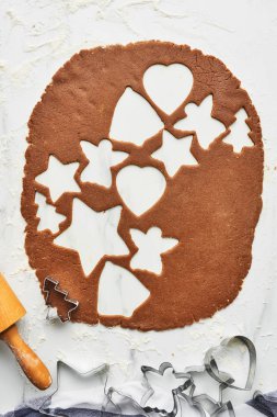 Zencefilli kurabiye hamuru ile çeşitli şekil kurabiye kesme. Arka plan Christmas gingerbread çerezleri fırın için pişirme. Kurabiye hamuru kesiciler ve oklava ile üstten görünüm beyaz mermer masada.