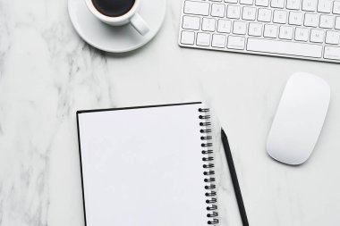 Beyaz bilgisayar klavye, fare, kahve fincanı ve defter kalem üzerinde beyaz mermer zemin ile iş kompozisyon. Office kavramı, kahve molası. Kopya alanı ile üstten görünüm