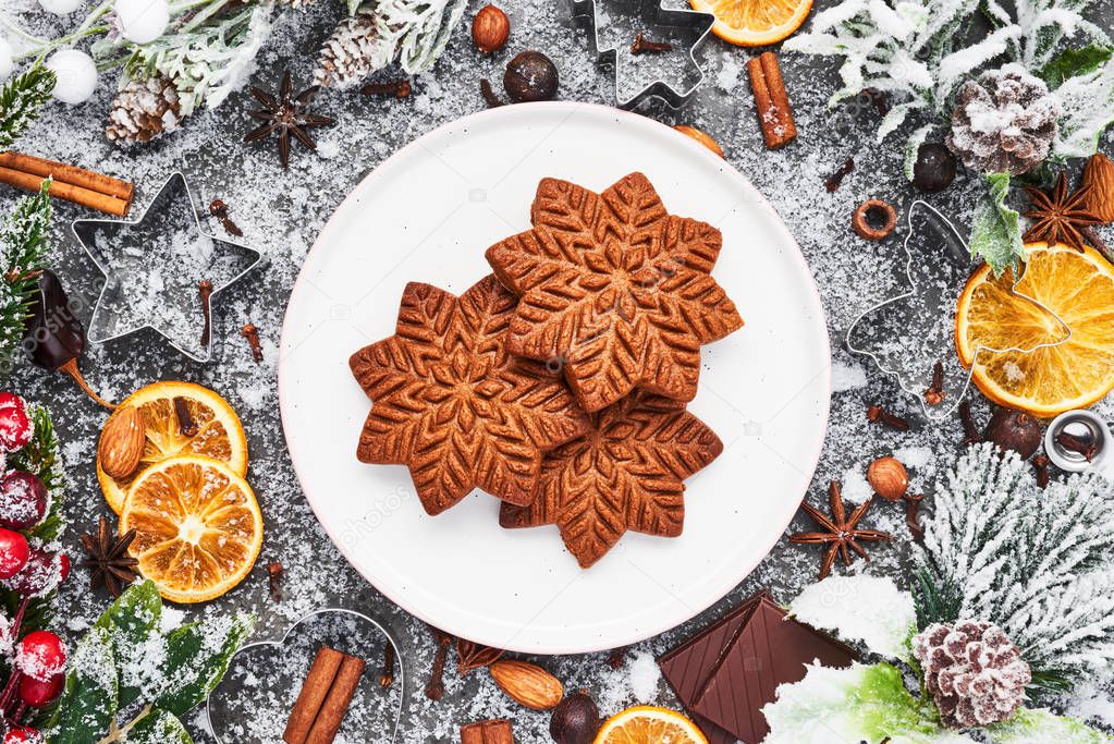 Holiday baking background. Christmas gingerbread cookies with cutters and spices on grey concrete table. Christmas food. Top view.