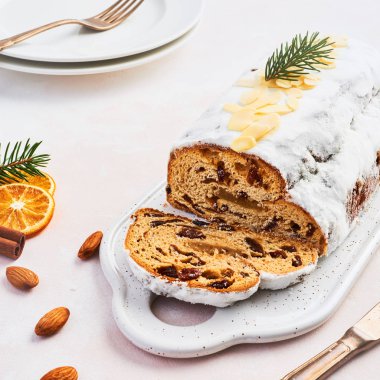 Şeker, badem ezmesi, badem ve kuru üzüm plaka hizmet veren beyaz üzerine krema ile Noel Stollen keki. Geleneksel Dresdner İsa pasta. Kare kırpma.