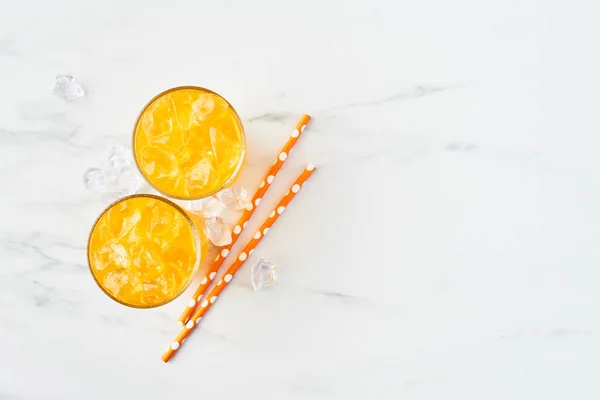 Taze turuncu, beyaz mermer üzerinde uzun bardak mango veya limon suyu