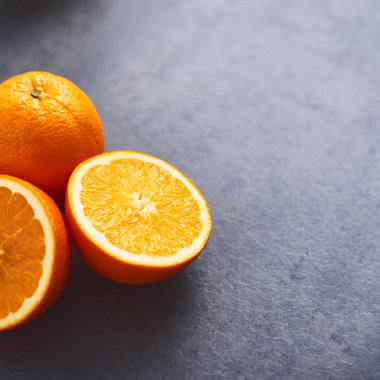 Koyu beton arka plan üzerinde turuncu dilimler. Metin için alan kopyalayın. Seçici odak. Kare kırpma.