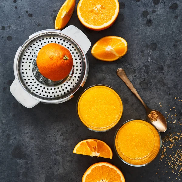 Yaz içeceği. Narenciye sıkacağı ve karanlık beton zemin üzerine portakal dilimleri ile uzun bardak taze portakal suyu. Görünüm sayfa, metin için yer Kopyala. Kare kırpma.
