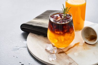 Soğuk yaz içeceği buz. Buz, organik portakal suyu şişe ile portakal suyu espresso ve boş espresso beyaz mermer plaka koyu arka plan üzerinde hizmet veren vurdu. Metin için yer kopyalayın.