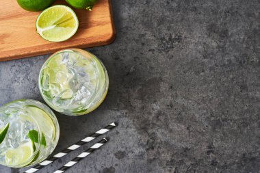 Limonata ya da limon, nane ve karanlık beton zemin üzerine buz mojito. Metin için yer kopyalayın. Üstten görünüm. Yaz içeceği.