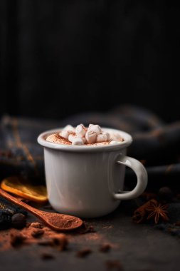 Sıcak kakao marshmallows retro kupa maddeler tarafından çevrili içkiyle: tarçın, portakal, anason ve koyu karanlık beton masa üzerinde üzerinde siyah ahşap arka plan. Kış içki. Rustik bak. Kopya alanı.