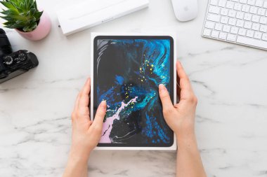 Zagreb, Hırvatistan - 18 Şubat 2019: Apple ipad Pro 11 inç Apple kalem 2 tarafından çevrili bir kutu holding kadınlar eller tablo bilgisayar ve kamera üzerinde beyaz mermer. iPad Pro 11 inç unboxing için hazır.