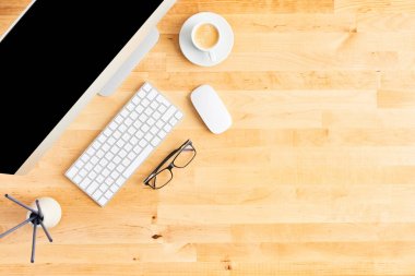 Ahşap ofis masasında büyük masaüstü bilgisayarın üst görünümü