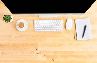 Ahşap ofis masasında büyük masaüstü bilgisayarın üst görünümü
