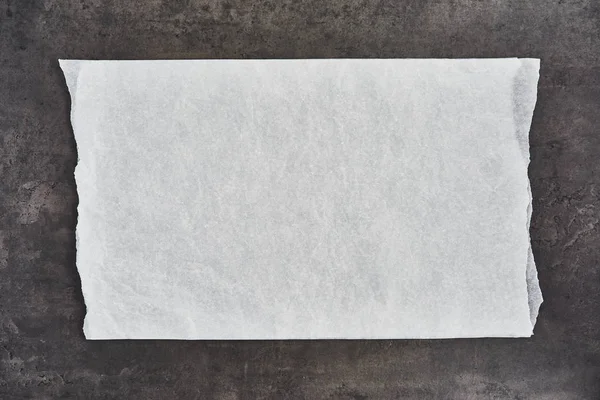 Trozo arrugado de pergamino blanco o papel para hornear sobre cóncavo negro — Foto de Stock