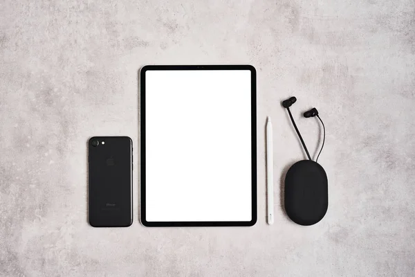 Tablet, matita, telefono e auricolari su sfondo grigio cemento . — Foto Stock