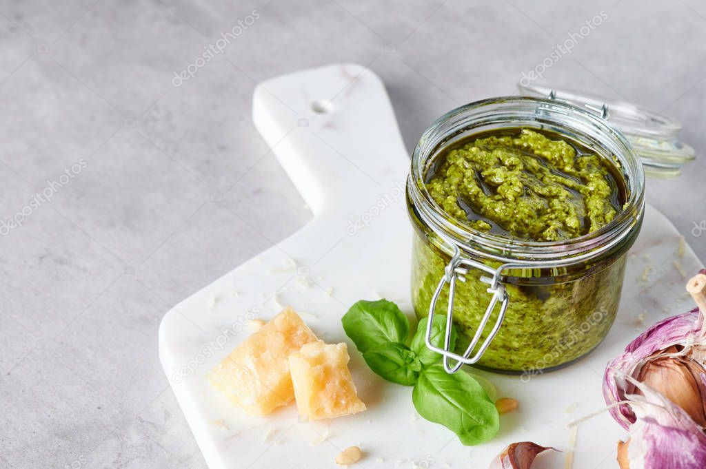 Pesto sauce or pesto genovese in a glass jar.