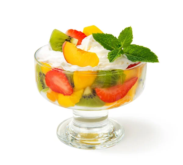 新鲜的水果沙拉 奶油和薄荷糖放在玻璃碗里 与白色背景隔离 图库照片