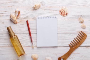 Ahşap arka plan güneş yağı, tarak, havlu, deniz kabuklarını, defter üstten görünüm kopya alanı deniz aksesuarları