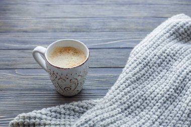 Ahşap arka plan üzerinde hatmi ile kahve fincan. Rahat kazak.