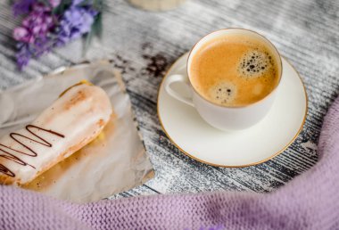 Fincan sıcak kahve, pasta ve çiçekler rustik ahşap masa, closeup fotoğraf sıcak kazak, kış sabah kavramı, üstten görünüm