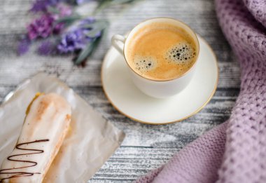 Fincan sıcak kahve, pasta ve çiçekler rustik ahşap masa, closeup fotoğraf sıcak kazak, kış sabah kavramı, üstten görünüm