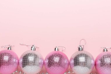 Pembe ve Noel topları Kağıt arka plan üzerinde gümüş. Üstten görünüm, düz yatıyordu, kopya alanı