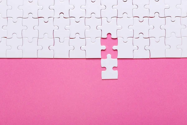 Witte Puzzel Roze Achtergrond Ontbrekend Stuk Bovenaanzicht — Stockfoto
