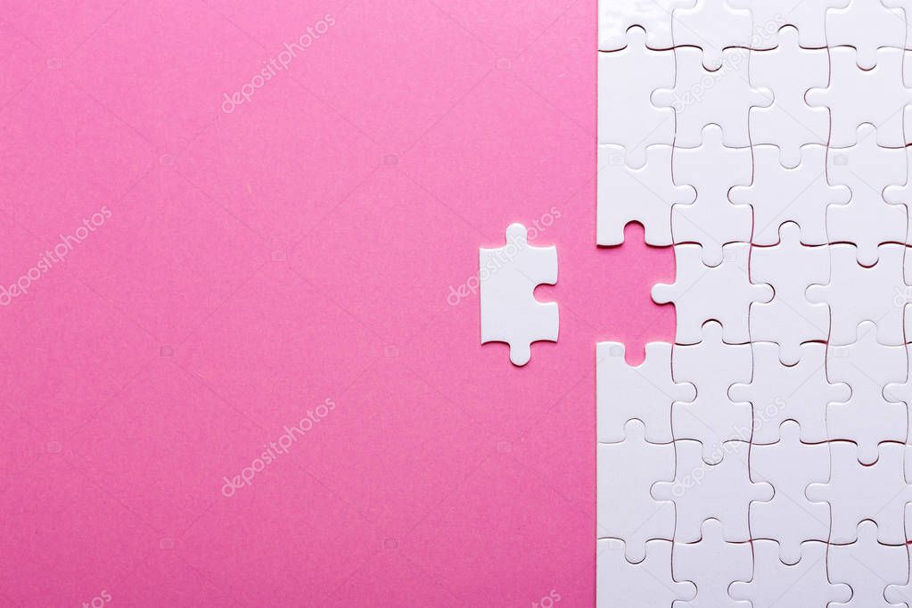 White puzzle on pink background. Missing piece. Top view