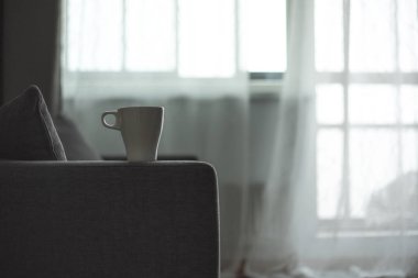 Bir fincan kahve. Gri kanepe. Büyük pencere. İskandinav tarzı. Kopya alanı