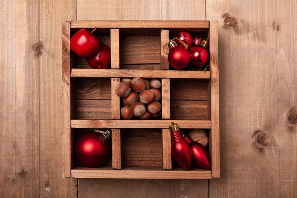 Wooden box with Christmas decorations on wooden table. Rustic style. Top view.
