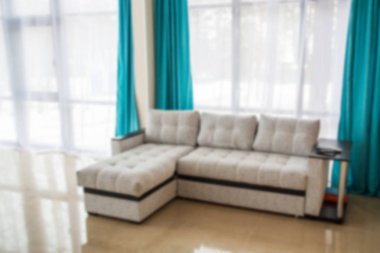 Gri kanepe ile bulanık oturma odası. Hafif iç. Mavi perde.