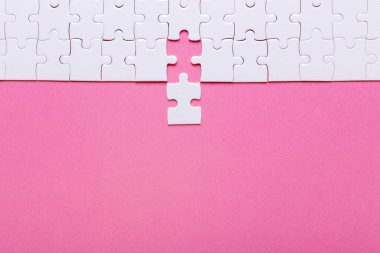 Pembe arka planda beyaz bulmaca. Kayıp parça. Üst görünüm