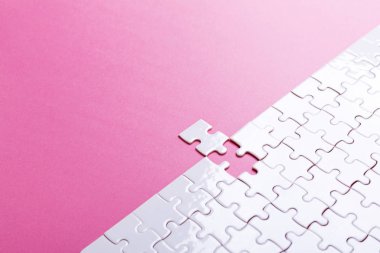 Pembe arka planda beyaz bulmaca. Kayıp parça. Üst görünüm