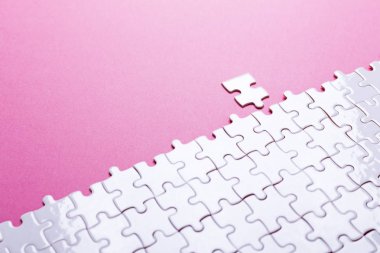 Pembe arka planda beyaz bulmaca. Kayıp parça. Üst görünüm
