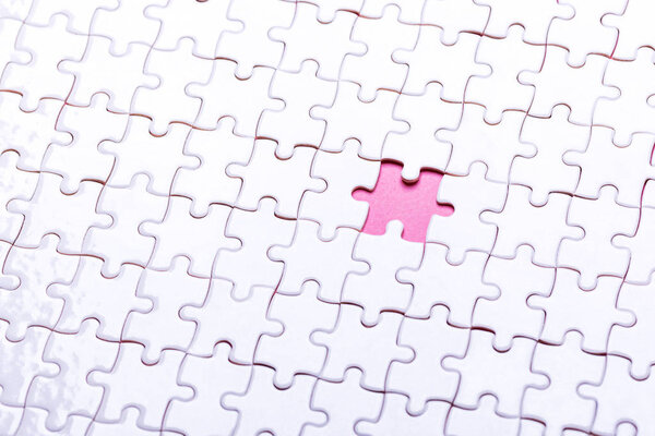 White puzzle on pink background. Top view