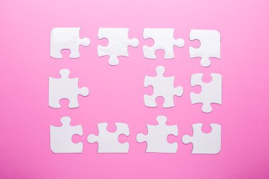 Pembe arka planda beyaz bulmaca. Kayıp parça. Üst görünüm