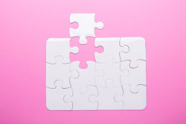 Pembe arka planda beyaz bulmaca. Kayıp parça. Üst görünüm
