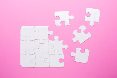 Pembe arka planda beyaz bulmaca. Kayıp parça. Üst görünüm