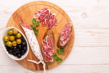 Salam ve ekmek Beyaz ahşap zemin üzerinde. Üstten görünüm. Kopya alanı