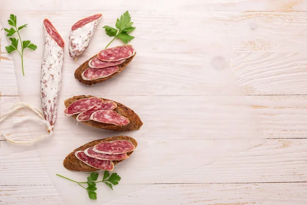 Salami Und Brot Auf Weißem Holzgrund Ansicht Von Oben Kopierraum — Stockfoto