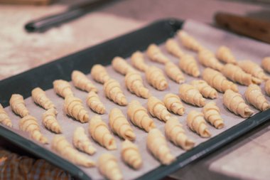 Ev yapımı simit bir fırın tepsisine. Ekmek pişirme için hazırlanmış. Noel kavramı. Vintage renklendirme