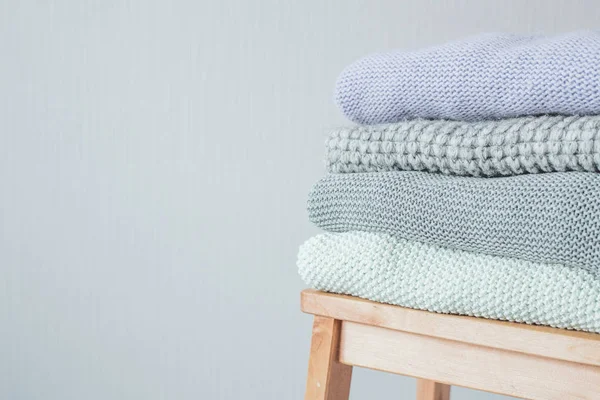 Ahşap merdiven rahat örme elbise yığını. Gri duvar. Vintage renklendirme