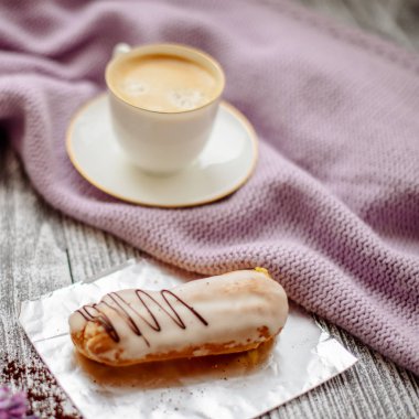 Bir fincan sıcak kahve, pasta ve çiçekler rustik ahşap masa, closeup fotoğraf sıcak kazak, kış sabah kavramı, üstten görünüm. Renkli vintage
