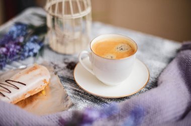 Bir fincan sıcak kahve, pasta ve çiçekler rustik ahşap masa, closeup fotoğraf sıcak kazak, kış sabah kavramı, üstten görünüm. Renkli vintage