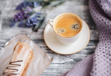 Bir fincan sıcak kahve, pasta ve çiçekler rustik ahşap masa, closeup fotoğraf sıcak kazak, kış sabah kavramı, üstten görünüm. Renkli vintage