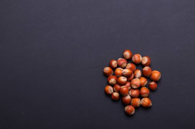 Avuç fındık siyah bir arka plan - sağlıklı snack. Üstten görünüm. Kopya alanı