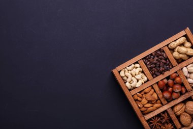 Siyah bir arka plan - sağlıklı bir ahşap kutu içinde fındık ürün yelpazesine snack. Üstten Görünüm. Kopya alanı