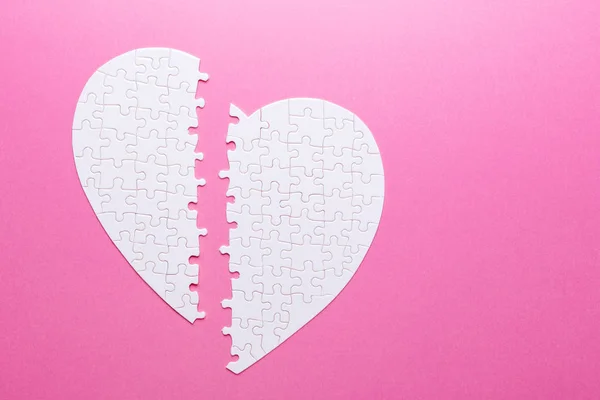 Wit puzzel gebroken hart op roze achtergrond. Bovenaanzicht — Stockfoto